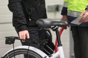 Kaksi ihmistä juttelee, toinen pitää kättään valkoisen polkupyörän tarakalla. Polkupyörähuolto Haminassa hoituu myös Ravimäen Työpalvelussa.