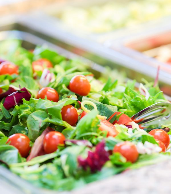 Suuri, vihreä salaatti, jossa on punaisia kirsikkatomaatteja. Ravimäen ravintolapalvelut järjestävät vaikka häät tai ristiäiset ravintoloissaan Haminassa.