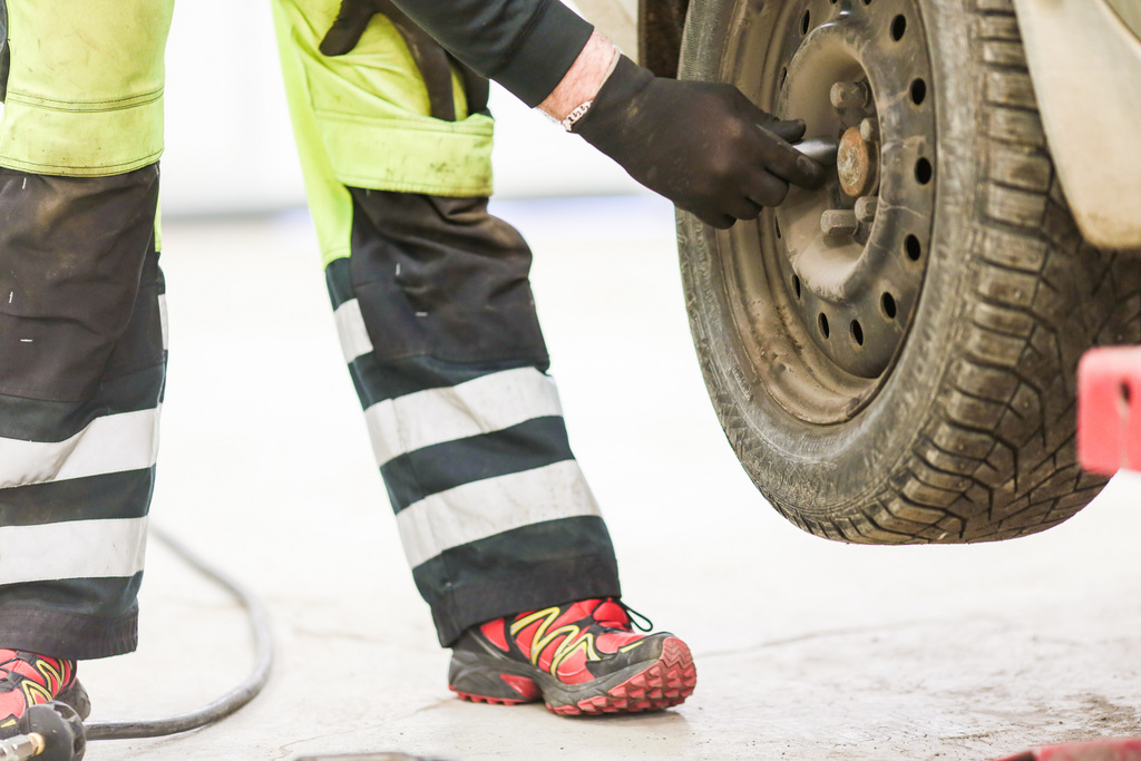 Mekaanikko kiristää renkaan pultteja. Työllistymistä edistävät palvelut Haminassa auttavat työstä poissaolevia takaisin työn pariin vaikka autotöihin.